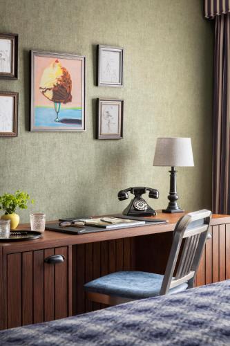 a desk with a phone and a chair in a room at Graduate by Hilton Storrs in Storrs