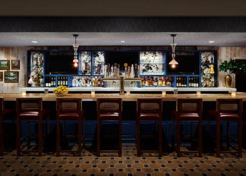 a bar with a row of stools in a restaurant at Graduate Storrs in Storrs