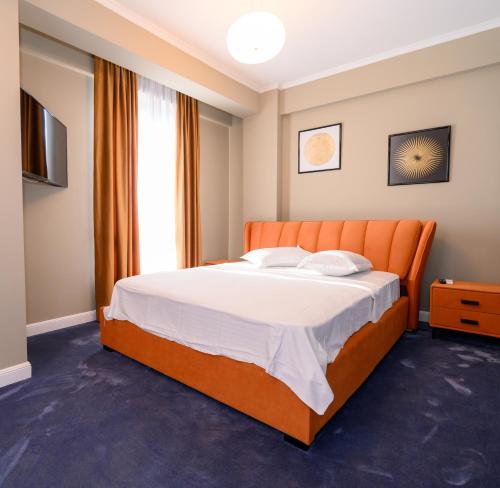 ein Schlafzimmer mit einem orangenen Bett und einem TV in der Unterkunft Aquarium Residence Penthouse 7 in Mamaia Nord – Năvodari