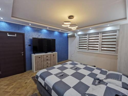 1 dormitorio con 1 cama y TV de pantalla plana en Apartman Cipi2, en Sombor