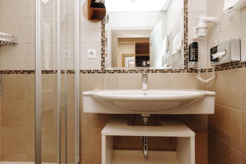 La salle de bains est pourvue d'un lavabo et d'une douche. dans l'établissement Hotel Garni Tannenhof, à Flachau