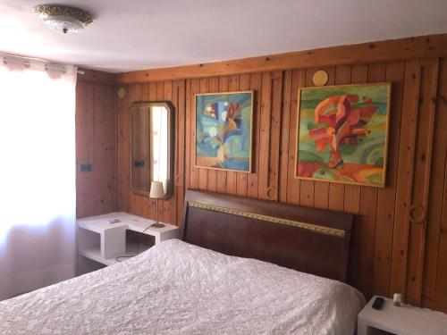 ベニッサにあるBonito apartamento villa Joyaの木製の壁のベッドルーム(ベッド1台、鏡付)
