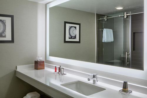 a bathroom with a sink and a large mirror at Houston Marriott South at Hobby Airport in Houston