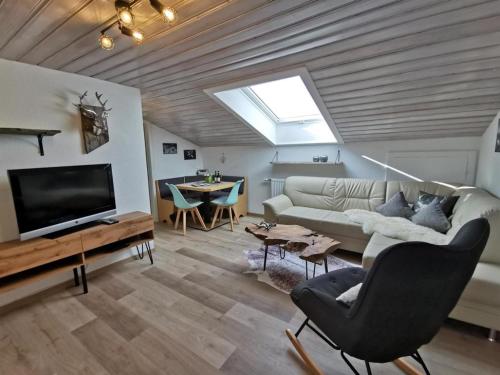 een woonkamer met een bank en een tv bij Ferienwohnungen Fischer in Fischen