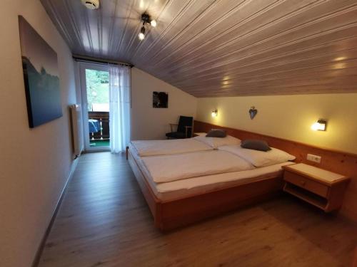 een slaapkamer met een groot bed en een houten plafond bij Ferienwohnungen Fischer in Fischen