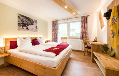 een slaapkamer met een bed en een bureau bij Landhaus Pichler in Tannheim