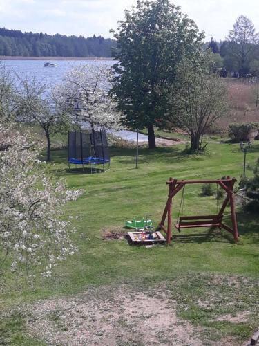 a park with a swing and a playground at Mazury Home in Giżycko