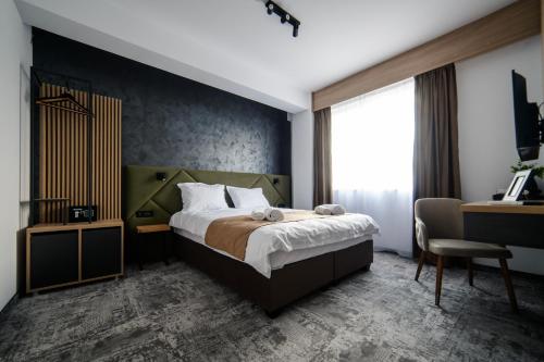 a bedroom with a bed and a desk and a chair at GBU Home Timisoara in Timişoara