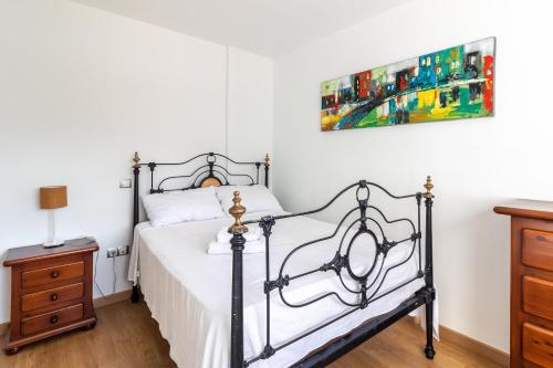 a bedroom with a bed and a painting on the wall at Flatguest Triana urbano in Las Palmas de Gran Canaria