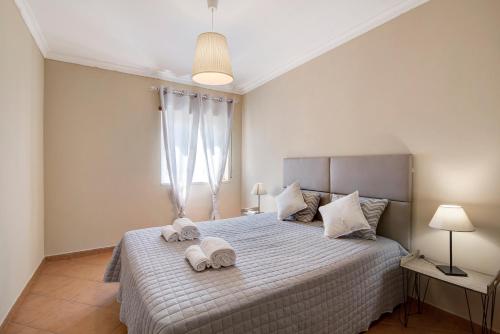a bedroom with a bed with towels on it at Marsalgado1 in Armação de Pêra