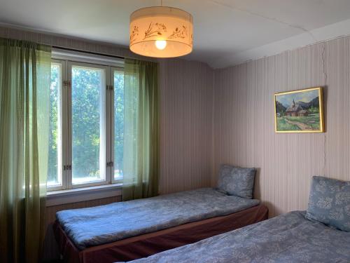 um quarto com 2 camas e uma janela em Uppleva att bo på en gammal gård em Kumlinge