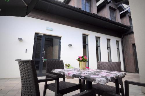 - une table et des chaises sur la terrasse dans l'établissement Czarna Dama Apartamenty, à Janowiec