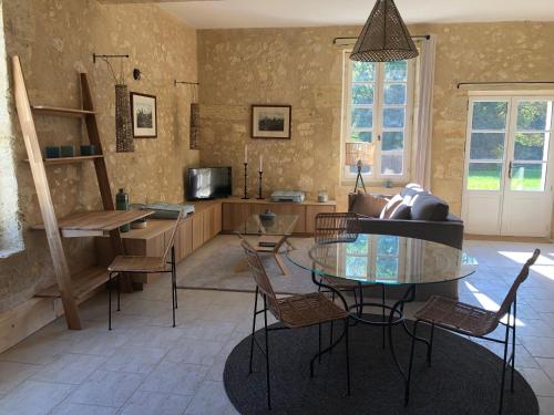 un salon avec une table en verre et un canapé dans l'établissement Les Bulles De Bordeaux, à Salleboeuf