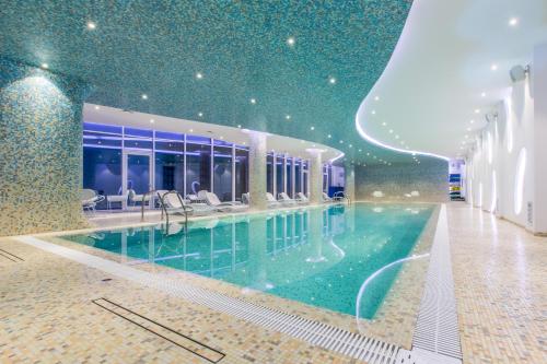 - une grande piscine dans un bâtiment doté d'un plafond dans l'établissement KADORR Hotel Resort & Spa, à Odessa