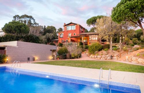 a house with a swimming pool in front of a house at Mas Ses Vinyes - Adults Only in Begur