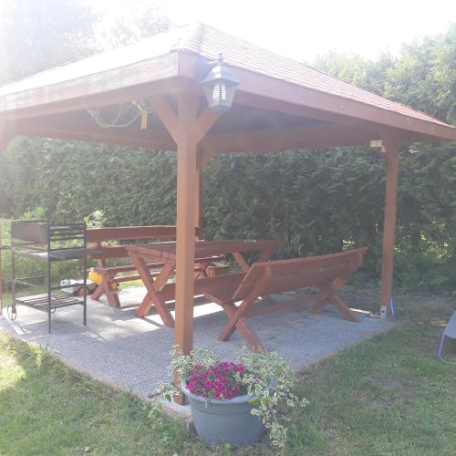 a wooden picnic table and bench under a pavilion at Mazury Home in Giżycko
