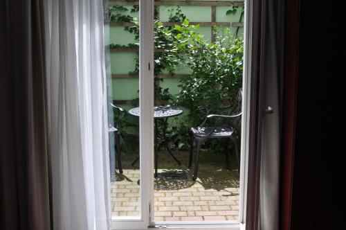 a sliding glass door with a table and a chair outside at Zum kleinen Riesen in Erfurt