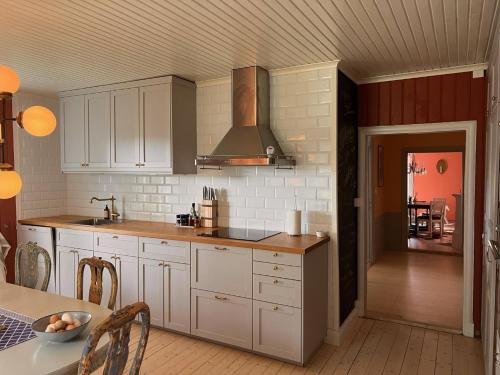 a kitchen with white cabinets and a stove at Herrgårdsflygel mitt i Sörmland in Malmköping