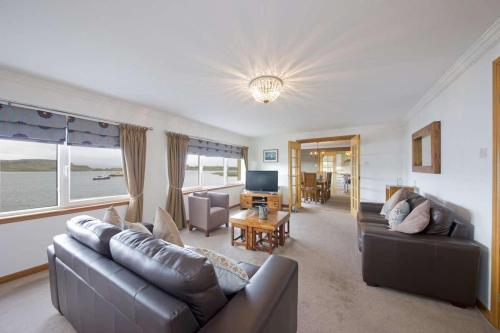 a living room with a couch and a television at Esplanade Court Holiday Apartments in Oban