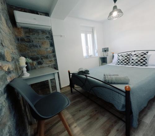 ein Schlafzimmer mit einem Bett und einem Stuhl darin in der Unterkunft Stone House in Sitia