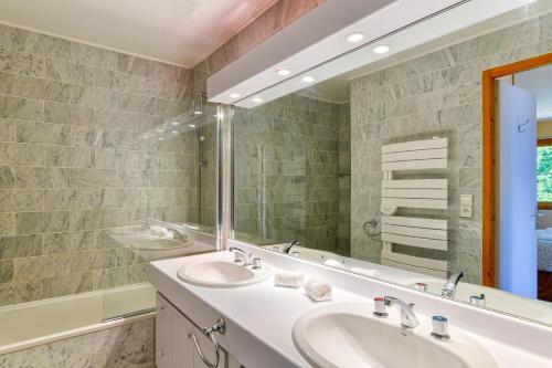 une salle de bain avec deux lavabos et un grand miroir dans l'établissement Les Terrasses de Bel Alp, à Saint-Gervais-les-Bains