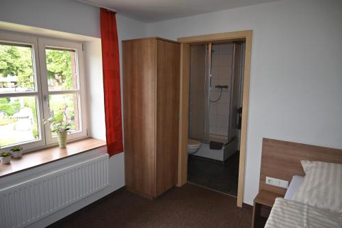 uma casa de banho com um WC, um lavatório e uma janela em Hotel Restaurant Zum Schwan em Goch