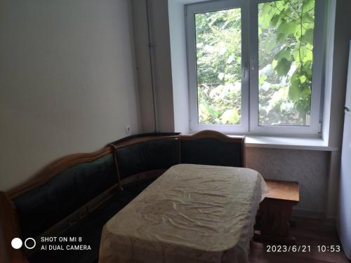 a bedroom with a bed in front of a window at Квартира на Агнии Барто in Dnipro