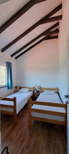 twee bedden in een kamer met houten vloeren bij Escape in nature in Stolac