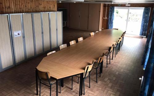 Centre Louis Delobbe في Olloy-sur-Viroin: وجود طاولة وكراسي خشبية كبيرة في الغرفة