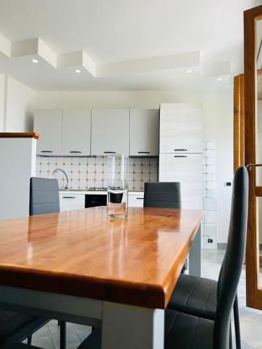 a kitchen with a wooden table with a wine glass on it at NEWHOUSE VICTORIA - Sea View Apartment in Nettuno