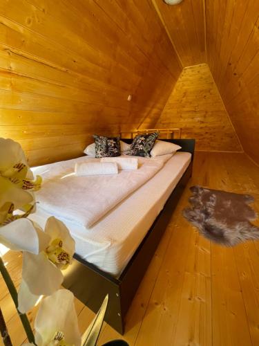 ein Schlafzimmer mit einem Bett in einer Holzhütte in der Unterkunft Casa Ursu in Cîrţişoara