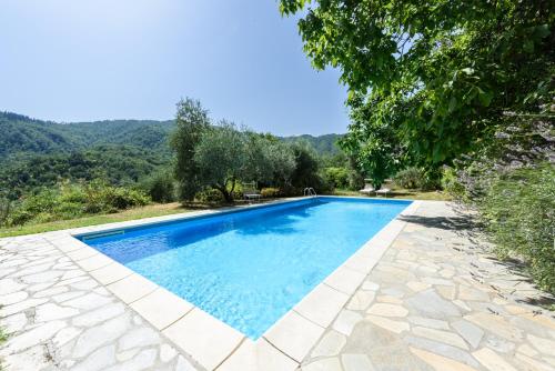 a swimming pool with blue water in a yard at Villa Feraldi in Scopeti