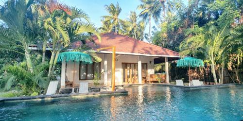 a house with a pool in front of a resort at Buntung Beach Villa in Gili Air