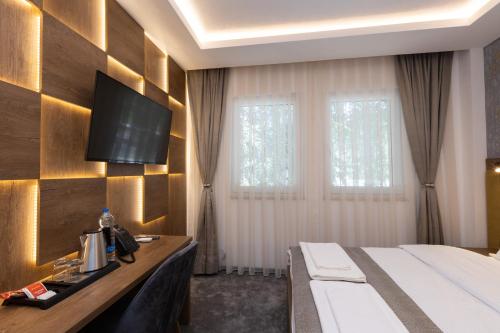 a hotel room with a bed and a television on a wall at Hotel M Star Novi Pazar in Novi Pazar