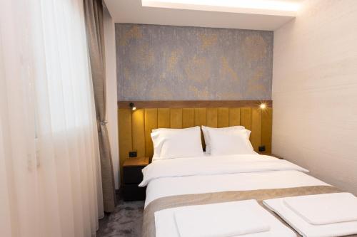 a bedroom with two beds and a painting on the wall at Hotel M Star Novi Pazar in Novi Pazar