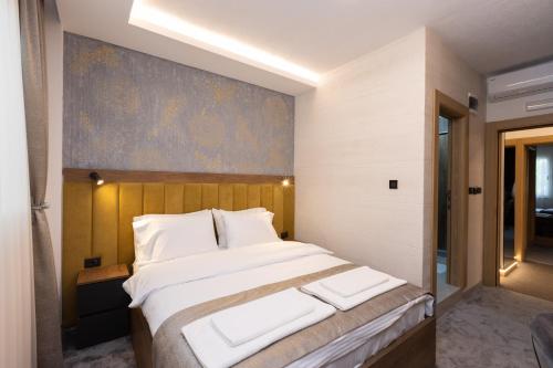 a bedroom with a large bed with a painting on the wall at Hotel M Star Novi Pazar in Novi Pazar