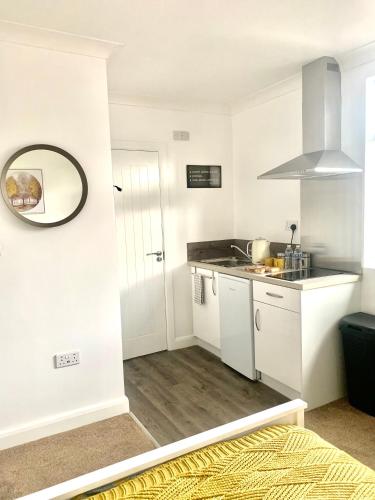 a small kitchen with white cabinets and a sink at Studio 22 Lower Road Beeston in Nottingham