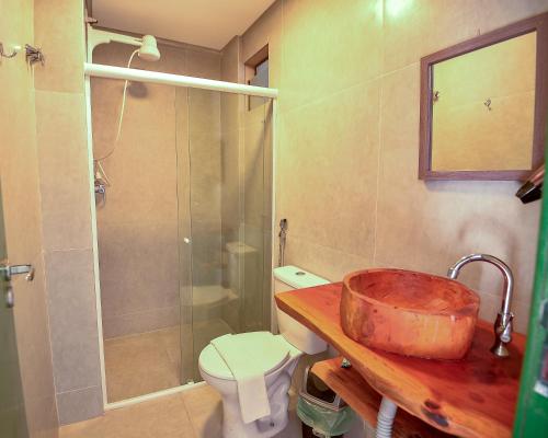 a bathroom with a sink and a shower and a toilet at Cocco Pousada in Maragogi