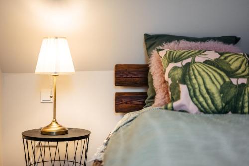 a bedroom with a bed with a lamp on a table at Boutique Chalet - Herke in Eitweg