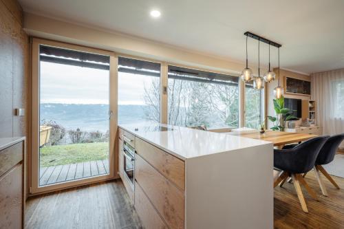 a kitchen with a large window and a table and chairs at Boutique Chalet - Herke in Eitweg