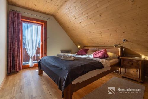 ein Schlafzimmer mit einem Bett und einem großen Fenster in der Unterkunft Chata Ellas in Vyšné Malatíny