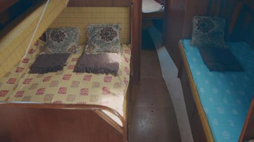 a bunk bed with pillows and a bedsheet at Jachta Varuna in Nida