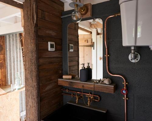 Łazienka z drewnianymi ścianami i umywalką w obiekcie The Tiny House w mieście Shootend