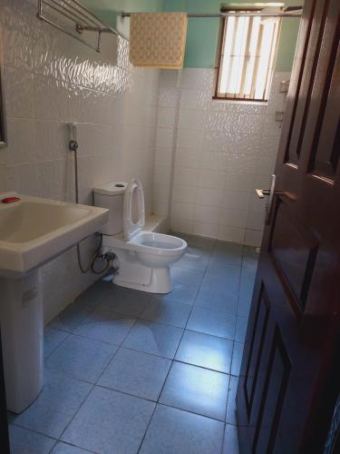 a bathroom with a toilet and a sink at Greatwall Gardens Athiriver in Machakos