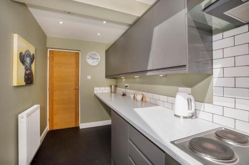 uma cozinha com um lavatório e uma bancada em Hollis House York- 4 bedroom with free parking em Strensall