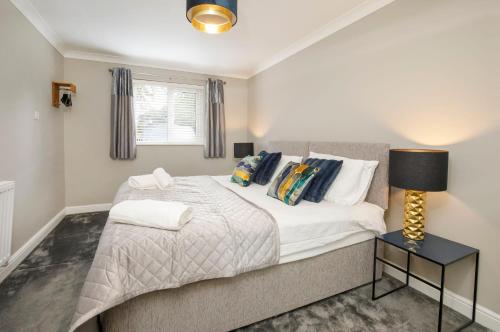 um quarto com uma cama e um candeeiro sobre uma mesa em Hollis House York- 4 bedroom with free parking em Strensall