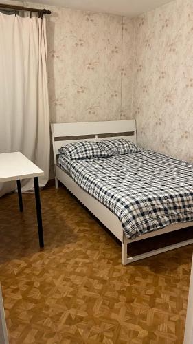 une chambre avec un lit et une table dans l'établissement Belle place pour votre voyage à Paris-Ladefense, à Houilles