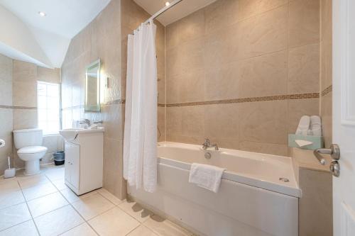 a bathroom with a bath tub and a toilet at 17 Hertford Street in London