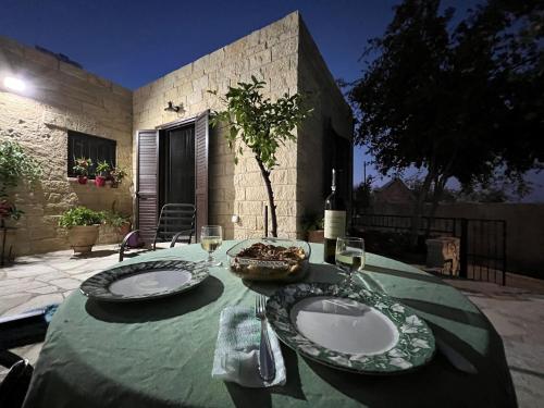 een tafel met twee borden eten en wijnglazen bij Cosy Piano village cottage in Pachna in Limassol