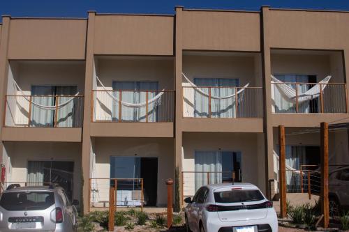 two cars parked in front of a building at Pousada Paraiso in Alto Paraíso de Goiás
